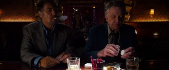 Movie still from “Stand Up Guys” (2012), directed by Fisher Stevens – Two men sitting at a table in front of candles; Medium shot, Over the shoulder angle