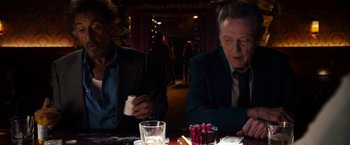 Movie still from “Stand Up Guys” (2012), directed by Fisher Stevens – A man sitting at a table in front of candles; Medium shot, High angle