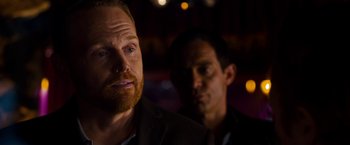 Movie still from “Stand Up Guys” (2012), directed by Fisher Stevens – A man with a beard is looking at the camera while another man looks on; Close Up shot, Over the shoulder angle