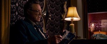 Movie still from “Stand Up Guys” (2012), directed by Fisher Stevens – An older man sitting in front of a lamp; Medium shot, Over the shoulder angle