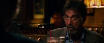 Movie still from “Stand Up Guys” (2012), directed by Fisher Stevens – A person sitting at a table with a drink; Close Up shot, Over the shoulder angle