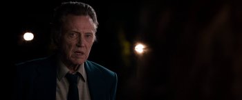 Movie still from “Stand Up Guys” (2012), directed by Fisher Stevens – An older man wearing a suit and tie in front of the sun; Close Up shot, Over the shoulder angle