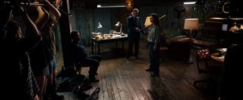 Movie still from “Stand Up Guys” (2012), directed by Fisher Stevens – A group of people standing in a room; Wide shot, High angle