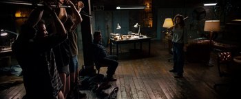 Movie still from “Stand Up Guys” (2012), directed by Fisher Stevens – A man sitting on a chair in a room; Wide shot, High angle