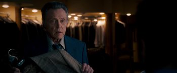 Movie still from “Stand Up Guys” (2012), directed by Fisher Stevens – An older man in a suit and tie in a store; Medium shot, Over the shoulder angle