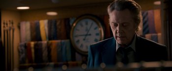 Movie still from “Stand Up Guys” (2012), directed by Fisher Stevens – A man in a suit and tie in front of a clock; Close Up shot, Low angle