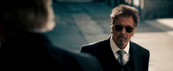 Movie still from “Stand Up Guys” (2012), directed by Fisher Stevens – A man in a suit and tie wearing sunglasses; Close Up shot, Over the shoulder angle