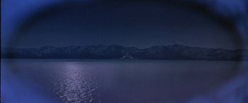 Movie still from “Starman” (1984), directed by John Carpenter – A boat in a body of water at night time; Extreme Wide shot, High angle