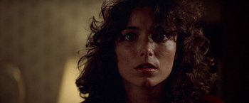 Movie still from “Starman” (1984), directed by John Carpenter – A woman's face in a dimly - lit room; Close Up shot, Low angle