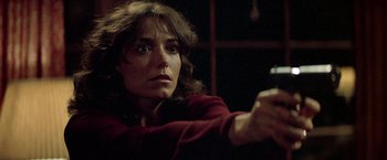 Movie still from “Starman” (1984), directed by John Carpenter – A woman holding a cell phone up to her face; Close Up shot, Over the shoulder angle