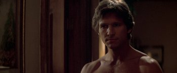 Movie still from “Starman” (1984), directed by John Carpenter – A shirtless man in a dark room looking at the camera; Close Up shot, Over the shoulder angle