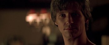 Movie still from “Starman” (1984), directed by John Carpenter – A man's face in a dark room; Close Up shot, Over the shoulder angle