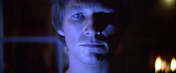 Movie still from “Starman” (1984), directed by John Carpenter – A person's face in the dark; Close Up shot, Over the shoulder angle