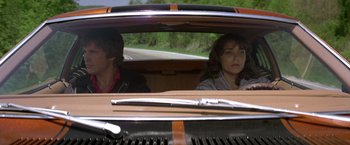 Movie still from “Starman” (1984), directed by John Carpenter – A man and a woman sitting in the back of a car; Medium shot, Low angle