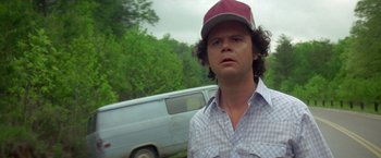 Movie still from “Starman” (1984), directed by John Carpenter – A man with a hat standing in front of a van; Close Up shot, Low angle