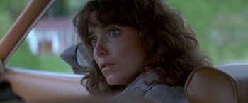 Movie still from “Starman” (1984), directed by John Carpenter – A woman's face in a parking lot; Close Up shot, Over the shoulder angle