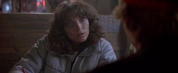 Movie still from “Starman” (1984), directed by John Carpenter – A person wearing a white jacket; Close Up shot, Over the shoulder angle