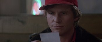 Movie still from “Starman” (1984), directed by John Carpenter – A man wearing a red hat holding a piece of paper; Close Up shot, Over the shoulder angle