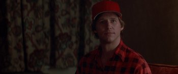 Movie still from “Starman” (1984), directed by John Carpenter – A man wearing a red hat and a plaid shirt; Close Up shot, Over the shoulder angle