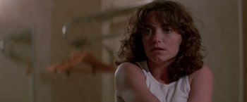 Movie still from “Starman” (1984), directed by John Carpenter – A person sitting in front of a window; Close Up shot, Low angle