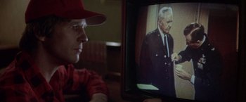 Movie still from “Starman” (1984), directed by John Carpenter – A man sitting in front of a television; Close Up shot, Over the shoulder angle