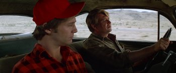 Movie still from “Starman” (1984), directed by John Carpenter – A man and a boy sitting in the back of a car; Close Up shot, Over the shoulder angle