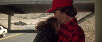 Movie still from “Starman” (1984), directed by John Carpenter – A man and a woman are kissing on the side of the road; Close Up shot, Overhead angle