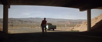 Movie still from “Starman” (1984), directed by John Carpenter – A man standing on a street next to a green truck; Extreme Wide shot, Low angle