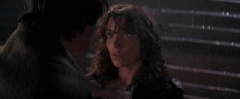Movie still from “Starman” (1984), directed by John Carpenter – A person with long curly hair; Close Up shot, Over the shoulder angle