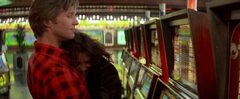 Movie still from “Starman” (1984), directed by John Carpenter – A woman and a man are looking at a computer screen; Medium shot, Low angle