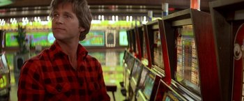 Movie still from “Starman” (1984), directed by John Carpenter – A man standing in front of a row of computer monitors; Close Up shot, Over the shoulder angle
