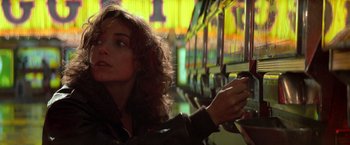 Movie still from “Starman” (1984), directed by John Carpenter – A woman with long red curly hair is holding a cell phone; Close Up shot, Low angle