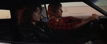 Movie still from “Starman” (1984), directed by John Carpenter – A man and a woman sitting in the back seat of a car; Medium shot, Over the shoulder angle