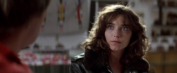Movie still from “Starman” (1984), directed by John Carpenter – A person wearing a leather jacket; Close Up shot, Over the shoulder angle