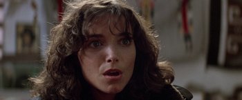 Movie still from “Starman” (1984), directed by John Carpenter – A person with a surprised look on their face; Close Up shot, Over the shoulder angle