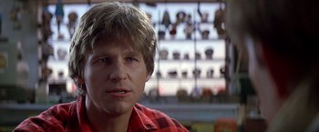 Movie still from “Starman” (1984), directed by John Carpenter – A person wearing a red and black plaid shirt; Close Up shot, Low angle