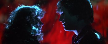 Movie still from “Starman” (1984), directed by John Carpenter – A man and a woman face to face in front of a red background; Close Up shot, Low angle