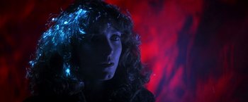 Movie still from “Starman” (1984), directed by John Carpenter – A person with curly hair; Close Up shot, Low angle