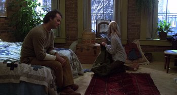 Movie still from “Stripes” (1981), directed by Ivan Reitman – A man and a woman sitting in a living room next to each other; Wide shot, High angle