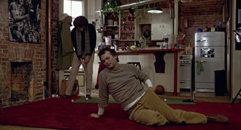 Movie still from “Stripes” (1981), directed by Ivan Reitman – A man laying on the ground in a room; Wide shot, High angle
