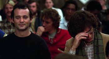 Movie still from “Stripes” (1981), directed by Ivan Reitman – A group of people sitting in a room; Close Up shot, Over the shoulder angle