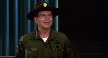 Movie still from “Stripes” (1981), directed by Ivan Reitman – A man wearing a hat and a uniform is smiling for the camera; Close Up shot, Low angle