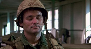 Movie still from “Stripes” (1981), directed by Ivan Reitman – A man wearing a hat and a camouflage uniform; Close Up shot, Low angle