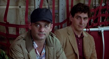 Movie still from “Stripes” (1981), directed by Ivan Reitman – Two men are sitting next to each other; Close Up shot, Low angle
