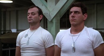 Movie still from “Stripes” (1981), directed by Ivan Reitman – A couple of men standing next to each other wearing white shirts; Medium shot, Low angle