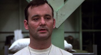 Movie still from “Stripes” (1981), directed by Ivan Reitman – A person wearing a white t - shirt; Close Up shot, Low angle