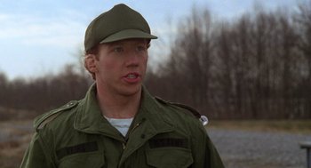Movie still from “Stripes” (1981), directed by Ivan Reitman – A man wearing a green jacket and a hat; Close Up shot, Low angle