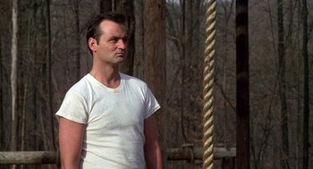 Movie still from “Stripes” (1981), directed by Ivan Reitman – A man standing in the middle of a rope course; Medium shot, Low angle