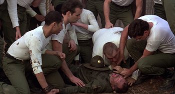 Movie still from “Stripes” (1981), directed by Ivan Reitman – A group of men surrounding a man in a uniform; Medium shot, High angle