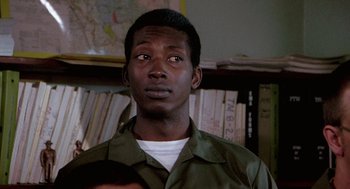 Movie still from “Stripes” (1981), directed by Ivan Reitman – A person wearing a green shirt; Close Up shot, Low angle